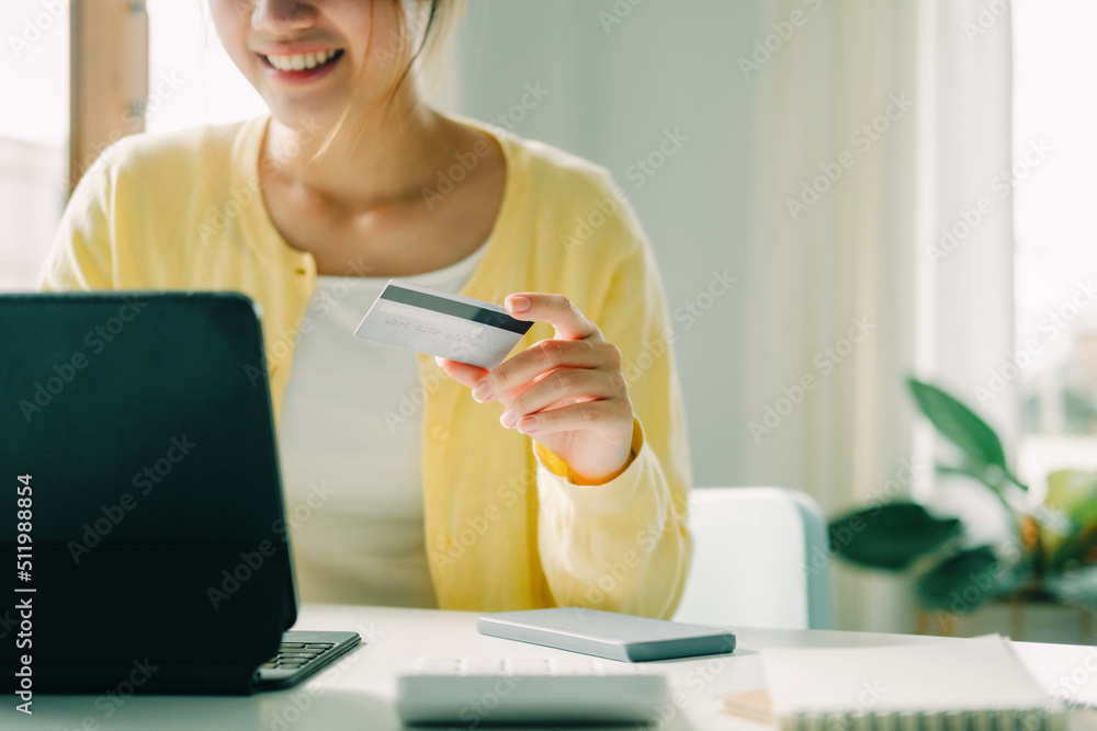 Wall mural woman using laptop and credit card for online shopping.