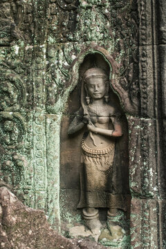 A sandstone carving depicting Apsara styling her hair at Ta Som Temple in Siem Reap Angkor Wat, Cambodia.