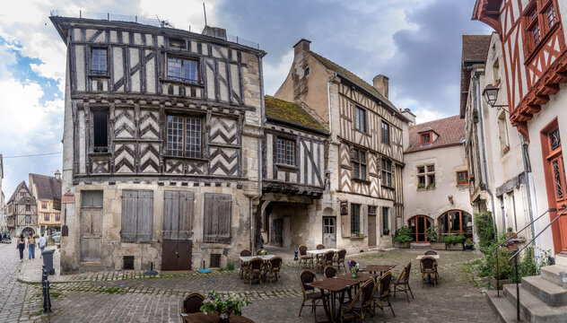 Brown, red half timbered houses, pillars and pinnacles on a cobble stone square of chalky granitic pavements in medieval Noyers sur  Serein in Yvonne, Bourgogne-Franche-Comt&eacute; in north-central France