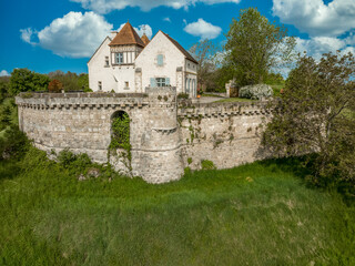 Fototapeta na wymiar Aerial view of Poncenat castle in central France surrounded by a wall with a semi circular tower