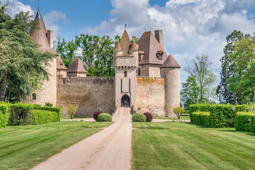 Fototapeta na wymiar View of Thoury castle in Saint-Pourain-sur-Besbre in Auvergne, feudal castle with fortified high curtain walls enclosing a courtyard, gate tower embellished with battlements and two towers 