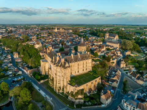 Sunset aerial view of Chateaudun  castle in Eure-et-Loire in France with imposing circular keep, Gothic high chapel, Renaissance residential palace and bell tower perched on a limestone outcrop