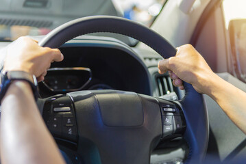 Human hand on the steering wheel drive car with buttons on the steering wheel for phone functions...