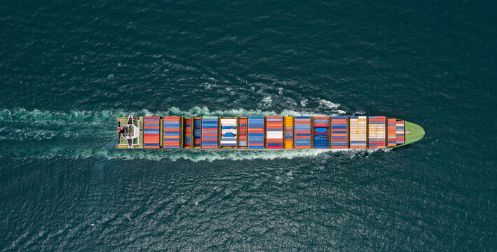 container cargo ship sailing full speed in pacific ocean to transport goods import export internationally or worldwide as business and industrial transport and marine services open sea 