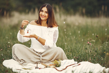 Adult woman showing meditation tool on meadow