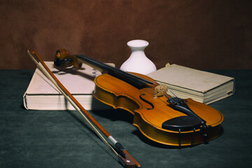 Still life with a violin, books and a white vase