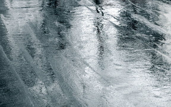 wet asphalt road with reflection of trees after heavy rain