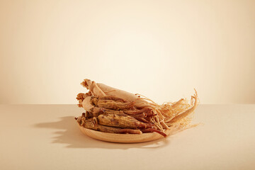 A front view of ginseng decorated in wooden dish in white background 