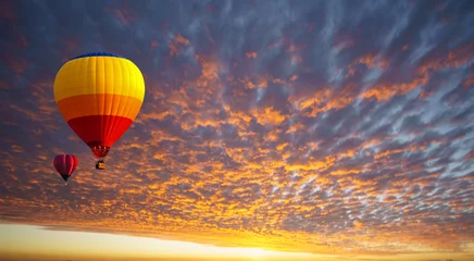 Deurstickers Hot air balloon floating in orange clouds like a sea of fire in the morning before sunrise. Balloons for sports and relaxation, recreation. © somchairakin