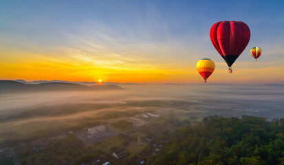 Hot air balloons above high mountain at sunrise, sunset. Colorful hot-air balloons flying over the mountain