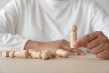 Woman and wooden human figures concept of recuitment, leadership, teamwork. Winner was pick up and...