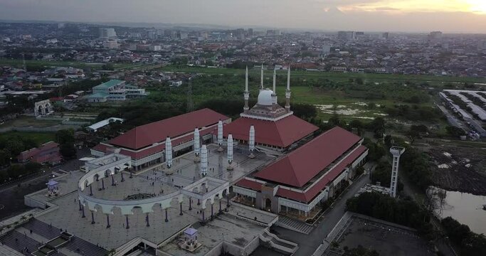 Aerial view of the great Mosque of Central Java (MAJT) in suset time. Th sun is orange and the weather is cloudy. The mosque have some umbrella that is closed
