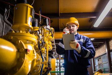 Refinery worker supervisor checking natural gas consumption and pipeline installations in...