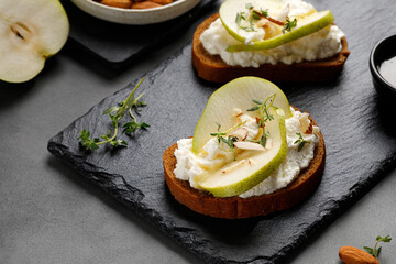 Bruschetta, snack, appetizers. Toast with cottage cheese ricotta cheese, pear, honey and almond....