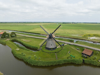 Historic traditional typical dutch old windmills mills on the rural countryside in green nature...