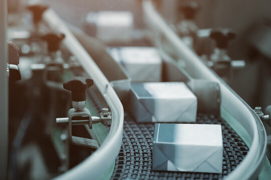 Paper box moving on packaging production line in a factory. Parcel, container or paper box transfer on conveyor belt. Industrial technology for paper, package and container factory.