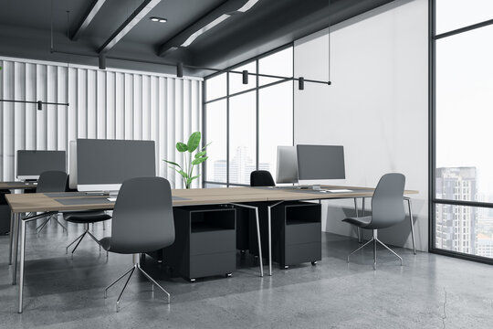 Perspective view on modern interior design coworking office with dark grey chairs, concrete floor, wooden tables and city view from huge windows. 3D rendering