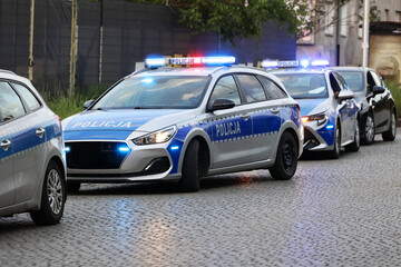 Samochód polskiej policji drogowej na sygnałach w mieście alarmowo. 