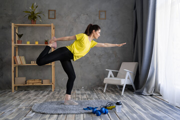 latin woman practicing yoga, sporty girl standing in half moon pose, Ardha Chandrasana exercise, working out at home