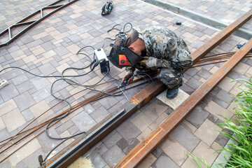 A worker works with metal welding at a construction site.