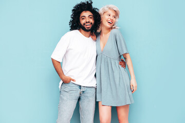 Fototapeta premium Smiling beautiful woman and her handsome boyfriend. Sexy cheerful multiracial family having tender moments on beige background in studio. Multiethnic models hugging. Embracing each other.Love concept