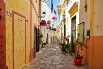 A narrow street between the old houses of Gallipoli, an old village in the province of Lecce in Italy. - obrazy, fototapety, plakaty