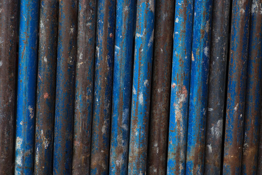 rust metal vertical lines background blue tubes scaffold industrial iron texture