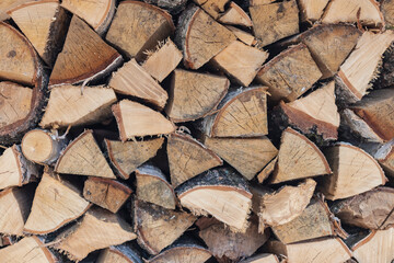 A pile of stacked birch firewood for the stove. Firewood in the woodpile. Natural background.