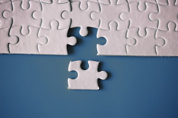 Clean puzzle elements on the red background. Empty puzzle piece on the table. Teamwork concept.