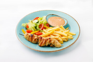 Grilled chicken fillet with salad and fries on a white background