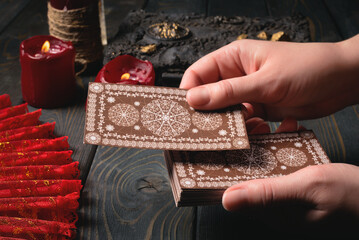 Tarot cards in fortune teller hands close up on the old wooden table background concept. Side view.