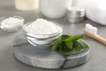 Fototapeta na wymiar Tooth powder and mint on grey table, closeup