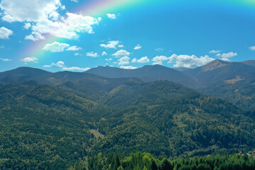 Fototapeta na wymiar Picturesque mountain landscape and beautiful rainbow in blue sky
