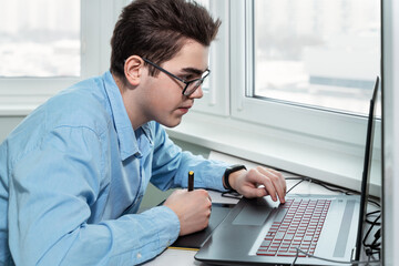 young male designer working on a professional graphics tablet with a pen