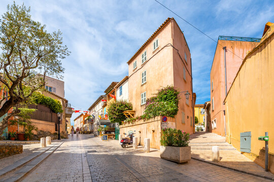 Fototapeta Colorful shops and buildings line the narrow, hilly alleys and streets in the Old town area of Saint-Tropez, France.