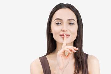 Young woman holding finger on her lips isolated closeup studio portrait, silent gesture