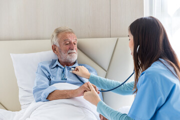 Obraz premium Caregiver nurse using stethoscope checking to Senior patient. Nurse helping stethoscope checking patient for listening heart rate at home