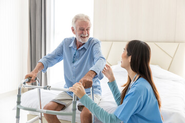 Caregiver nurse take care a Senior patient. Nurse helping senior Man hand holding walker trying to...