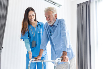 Caregiver nurse take care a Senior patient. Nurse helping senior Man hand holding walker trying to walk