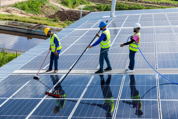 Worker Cleaning solar panels with brush and water. Worker cleaning solar modules in a Solar Energy Power Plant