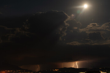 Naklejka na ściany i meble Night thunderstorm in the light of the moon. Amazing view