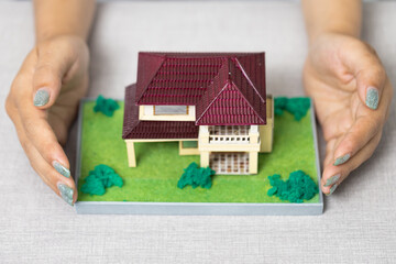 ็Hands protect the house, Real estate and property insurance concepts - residential protection.
