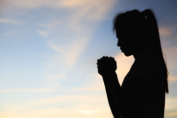 Silhouette of The girl  prayed  in the mountains to think of a loving God, we praise God.