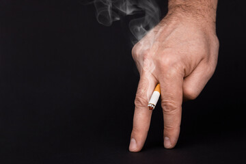 Cigarette in the fingers of the concept of causing impotence, close-up