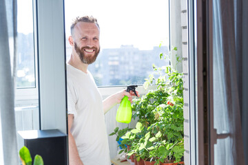 Man growing city balcony garden - 512017444