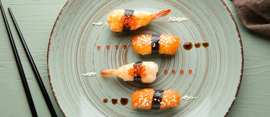 Plate with tasty sushi on table, top view