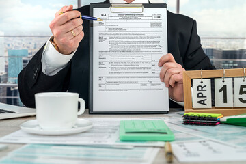 Businessman making calculation financial annual report and after fill 1040 tax form