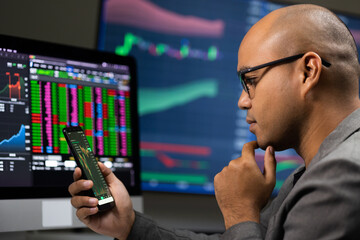 Obraz premium Investor businessman analyzing a graphic of a stock cryptocurrency exchange chart and looks at computer monitor. Financial analyst working with real-time exchange rate diagram. Investment concept