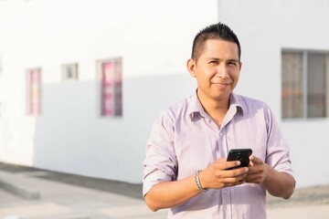 Hispanic man checking smartphone. Casual Ecuadorian man. Copyspace.