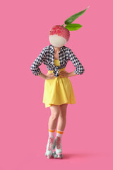 Woman with ripe litchi fruit instead of her head and on roller skates against pink background